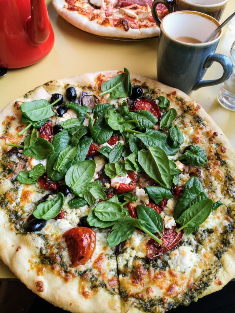 Pizza with goats cheese, pesto, sun dried tomato, olives and spinach in Joe's Cafe, Lahinch